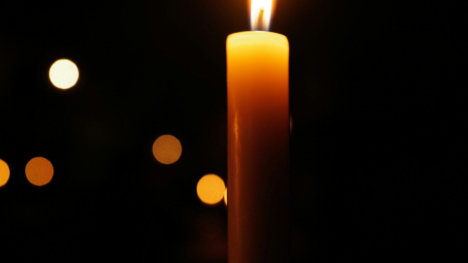 A single candle glowing in soft light